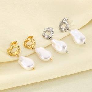 Detail of gold and silver irregular baroque pearl earrings on soft pleated silk