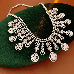 Detailed macro view of silver necklace with pink teardrop gems and zircon flowers