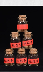 Set of 6 glass vials with cork stoppers containing osmanthus scented handmade incense pearls