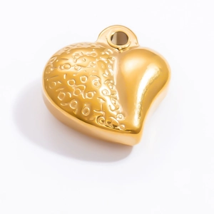 Gros plan sur pendentif cœur en or 18k avec texture martelée et finition polie