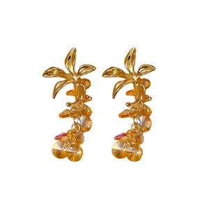 Vintage golden palm leaf earrings with dangling yellow crystal tassels on white background