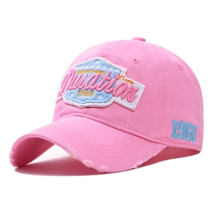 Detailed close-up of pink distressed cotton baseball cap with vintage 1968 embroidery