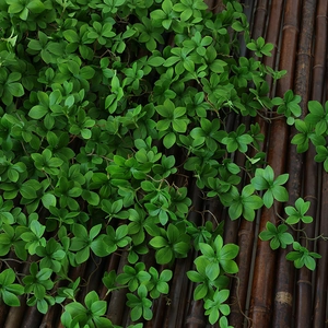 Artificial green vine plant on dark bamboo mat for home decoration and wall coverage