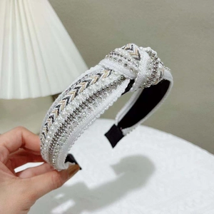 Detail of hand-held knotted headband with white pearls and champagne bead embroidery