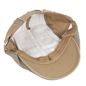 Detail of khak and olive flat cap lining with striped fabric and metal buckle
