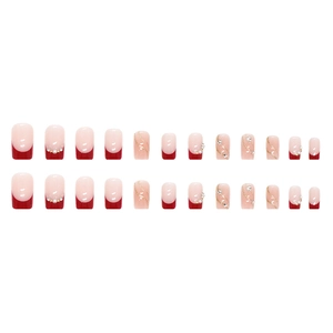 Faux ongles French rouge et blanc avec perles, cristaux et détails dorés ondulés