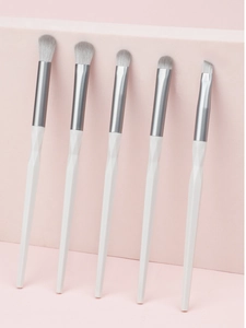 Detailed view of 5 eye makeup brushes with white rhombic handles and silver ferrules