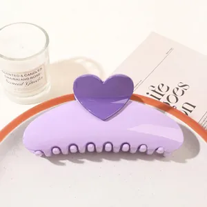 Detail view of a lavender heart-shaped hair claw clip on a white plate with aesthetic decor