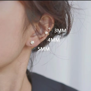 Close-up of 925 sterling silver zircon studs in 3mm, 4mm, and 5mm sizes on ear