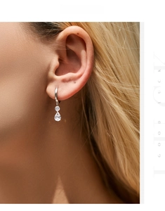 Gros plan de boucles d'oreilles en argent avec pendentif goutte en zircon sur modèle