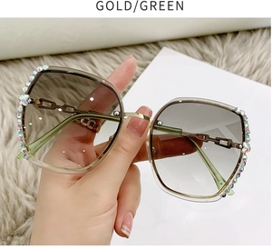 Close-up of rimless gradient green sunglasses with gold frame and sparkling rhinestones