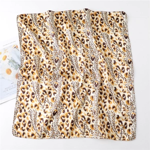 Macro detail of leopard print satin square scarf showing smooth silky texture and glossy finish