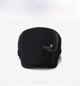 Detail of black cotton flat cap with sports embroidery and silver skull charm