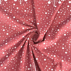 Close-up of soft wine red fabric with white polka dots showing smooth texture and drape