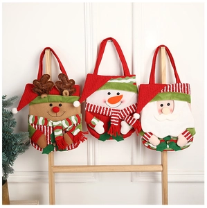 Three festive Christmas gift bags with reindeer, snowman, and Santa characters on a wooden ladder