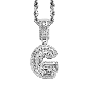 Macro detail of silver hip hop necklace with letter G pendant encrusted with white zircons