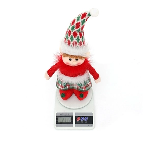 Christmas elf doll on a scale showing 211.3g weight with festive red and green attire