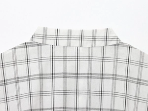 Vue détaillée du motif à carreaux noir et blanc et de la couture du col d'une veste chemise
