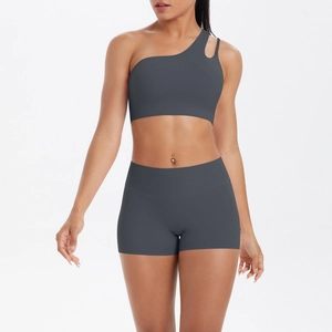 Detail of dark grey one-shoulder yoga bra and high-waisted gym shorts set on model