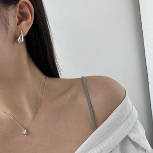 Close-up of model wearing 925 silver water drop pendant necklace and matching stud earrings