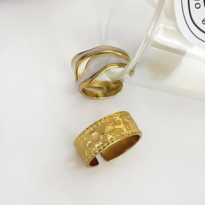 Gold-plated titanium steel rings featuring white enamel wave design and hammered metal texture