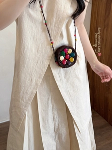 Close-up of bohemian mini round bag with colorful decorative discs and bead strap