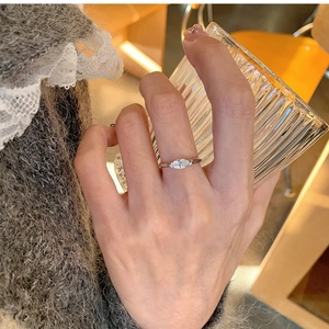 Close-up of marquise-cut crystal ring in silver finish worn in a casual cafe setting