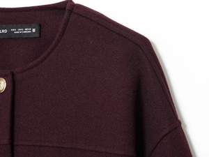 Detailansicht der weinroten Wolljacke mit Strukturstoff und geprägten Goldknöpfen