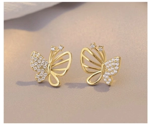 Macro detail of gold butterfly stud earrings with micro-pave cubic zirconia and filigree wings