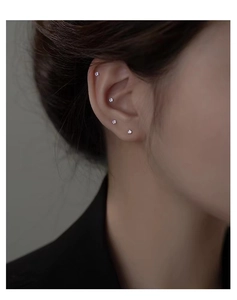 Close-up of S999 sterling silver stud earrings with colorful zircons on a model's ear