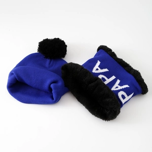 Detail of blue knitted neck warmer with PAPA text and thick black faux fur lining