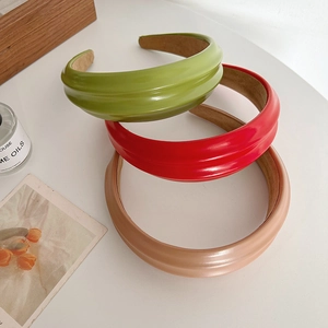 Cerchietti per capelli larghi lucidi in verde, rosso e beige su sfondo bianco
