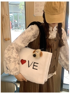 Detail shot of white fleece tote bag with LOVE embroidery and a plush dog charm attached