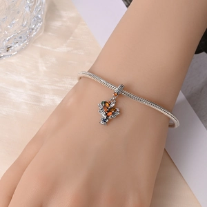 Detail of silver snake chain bracelet featuring a colorful gemstone maple leaf charm