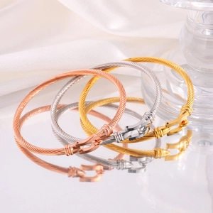 Macro shot of three-tone twisted cable bracelets with polished horseshoe clasps