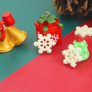 Detailed view of DIY resin Christmas charms featuring snow flakes and tiny gift boxes