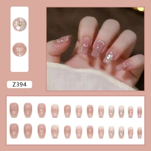 Détail de faux ongles avec fleurs 3D blanches, perles et design dégradé rose élégant