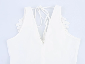 Detailed back view of white dress with crochet lace trim, V-back cut, and lace-up tie