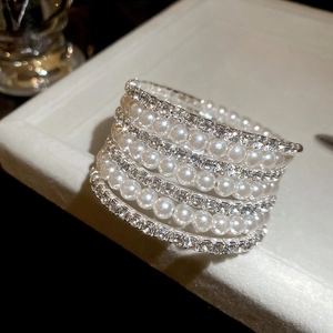 Macro shot of multi-layer pearl bracelet with silver diamond stripes on jewelry tray
