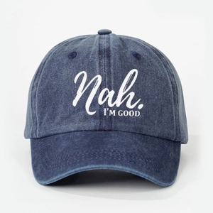 Detailed view of dark blue washed denim baseball cap with Nah. I'M GOOD. white text print