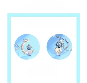 Detailed close-up of astronaut pendant featuring blue glitter and gold plating