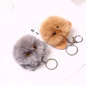 Close-up of fluffy grey and brown cat plush keychains with silver metal lobster clasps