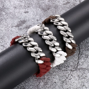 Three Cuban chain bracelets in brown white and red-brown displayed on a black pillar stand