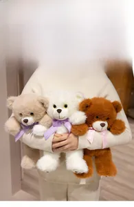 Detailed view of plush teddy bears in beige, white and brown with polka dot bow ties