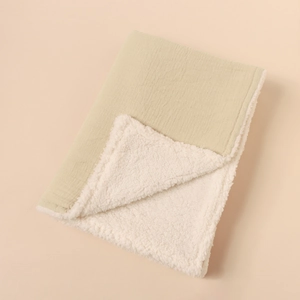 Detail of sage green muslin and soft white sherpa fleece double-layer baby blanket
