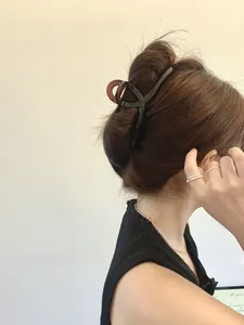 Detail of a large 13cm bicolor hair claw clip in black and dark brown on a model