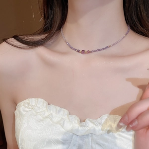 Close-up of elegant purple amethyst beaded necklace with gold accents on female neck