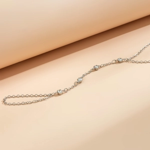 Detail of silver chain hand harness with sparkling crystals on soft pink background