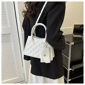 Close-up of white quilted PU leather crossbody bag with matching mini coin purse