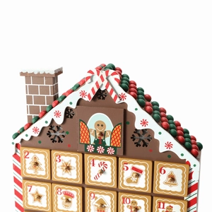 Close-up of a wooden gingerbread house advent calendar with 24 small numbered drawers